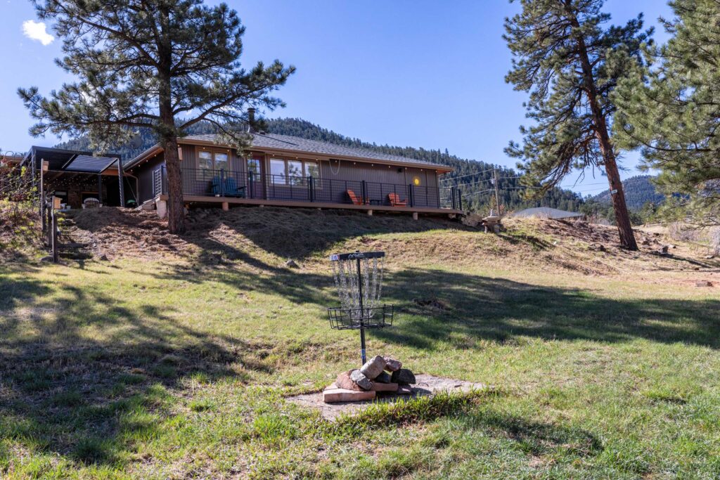 backyard with open grass and mature trees Pinewood Springs Colorado foothills property