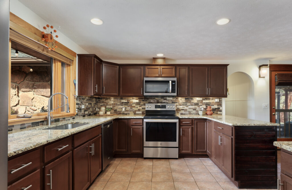 “kitchen with double island open to living and dining Pinewood Springs home” 